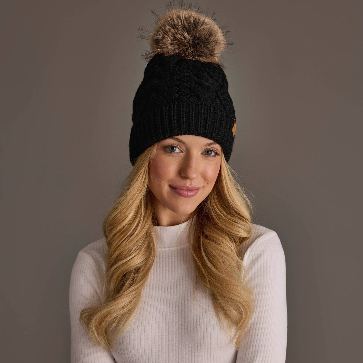 Panache Apparel Co. black cable knit pom hat with faux fur pom