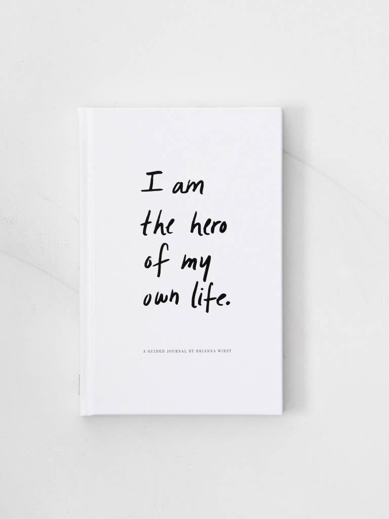 White book with black text 'I am the hero of my own life' on a light gray background
