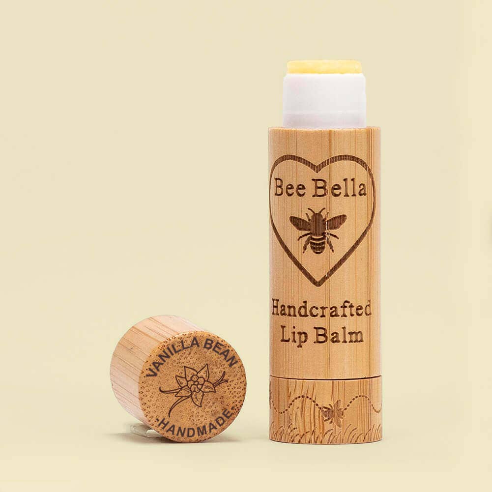 Bee Bella lip balm with wooden container on a beige background
