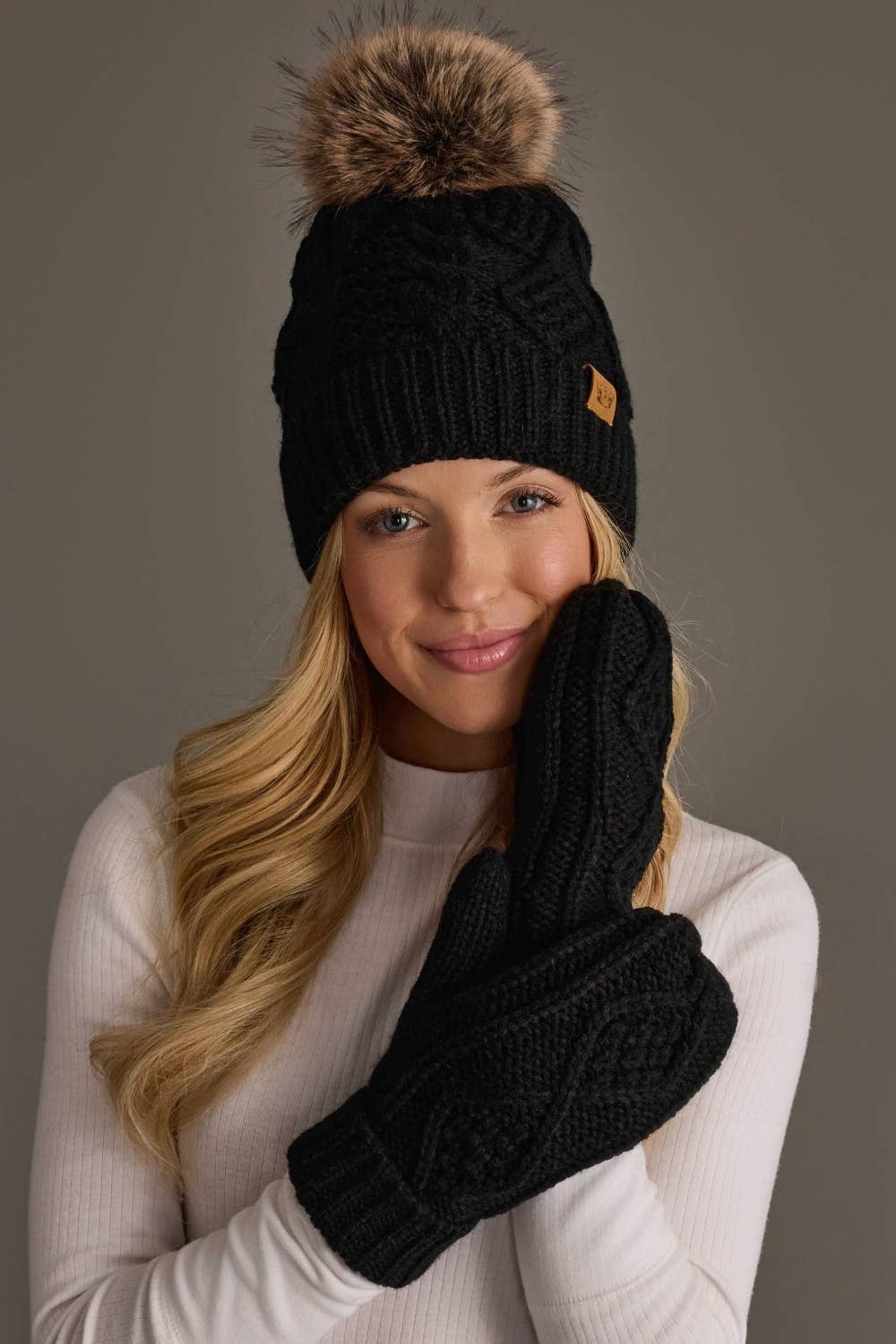 Panache Apparel Co. black cable knit pom hat with faux fur pom