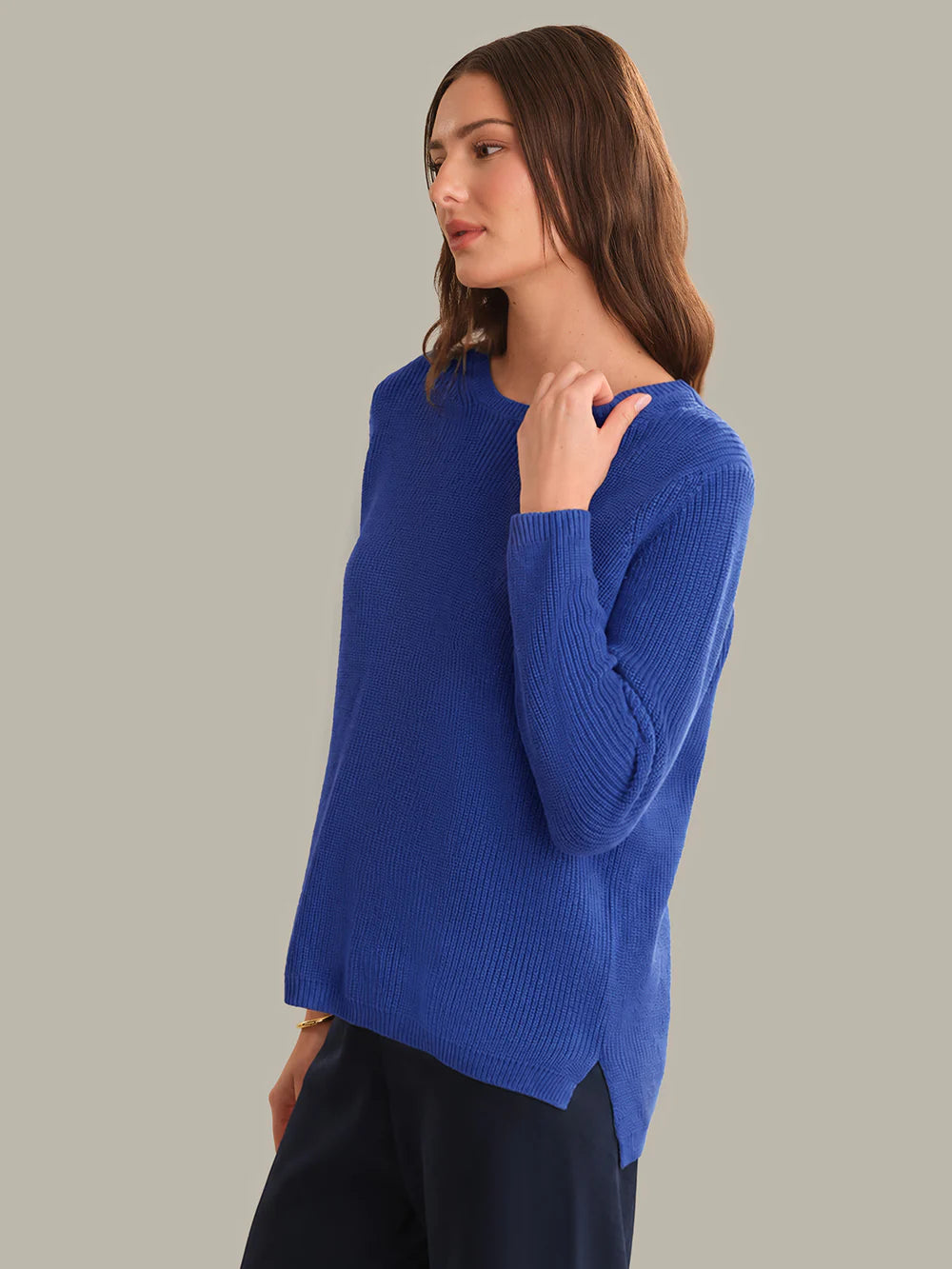 Woman wearing a blue sweater against a gray background