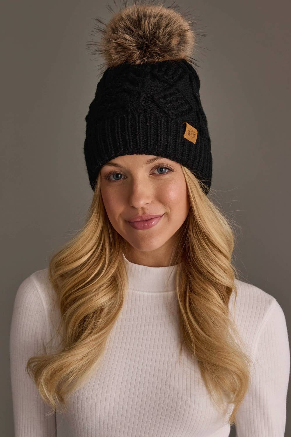 Panache Apparel Co. black cable knit pom hat with faux fur pom