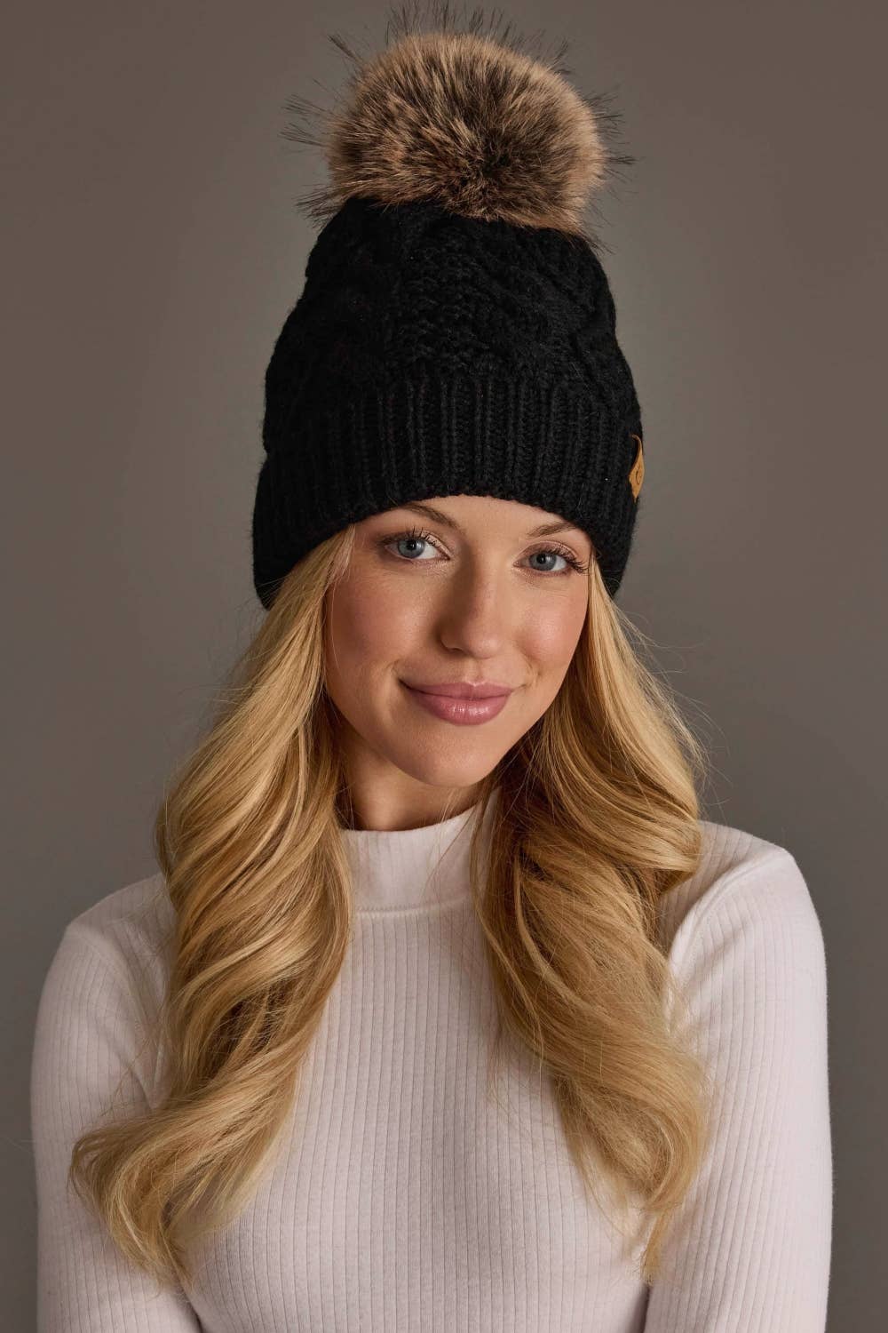 Panache Apparel Co. black cable knit pom hat with faux fur pom