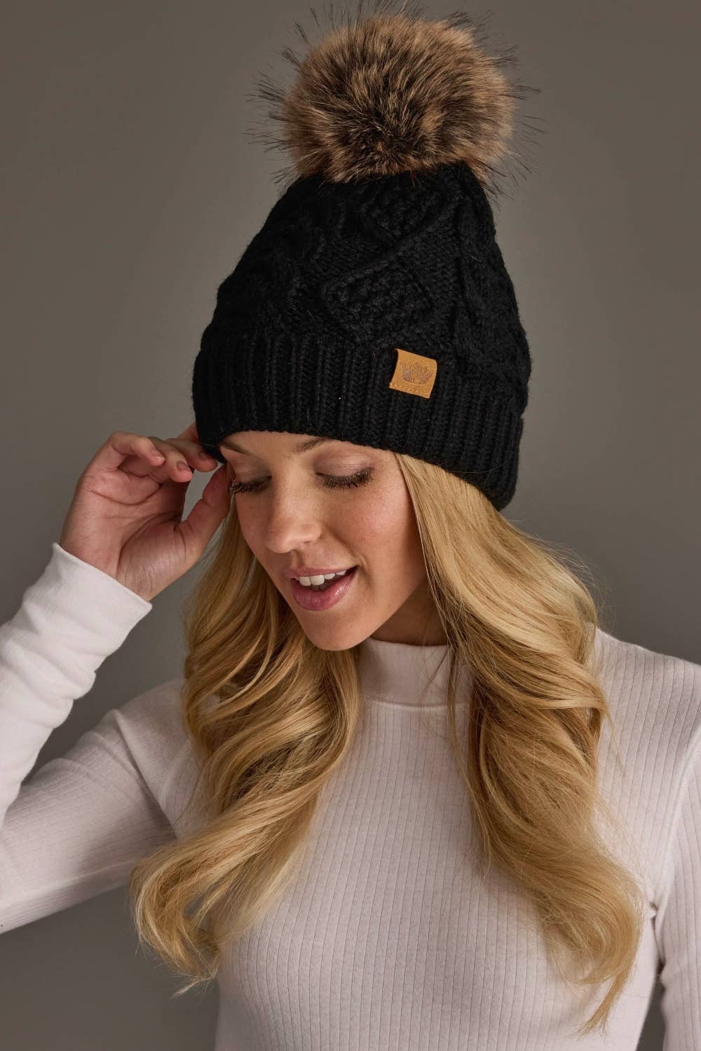 Panache Apparel Co. black cable knit pom hat with faux fur pom