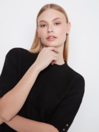 Black elbow sleeve sweater by Charlie B with mock neckline and button detail at the cuffs