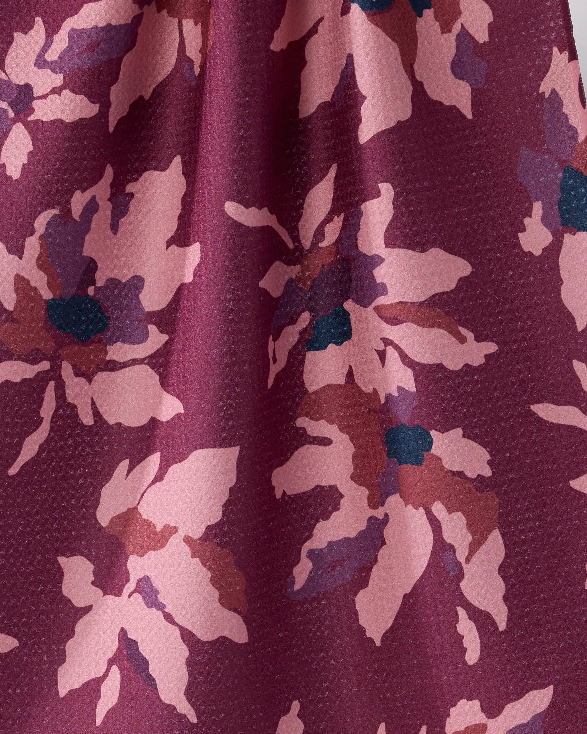 Close-up of a fabric with a floral pattern in shades of purple and pink.