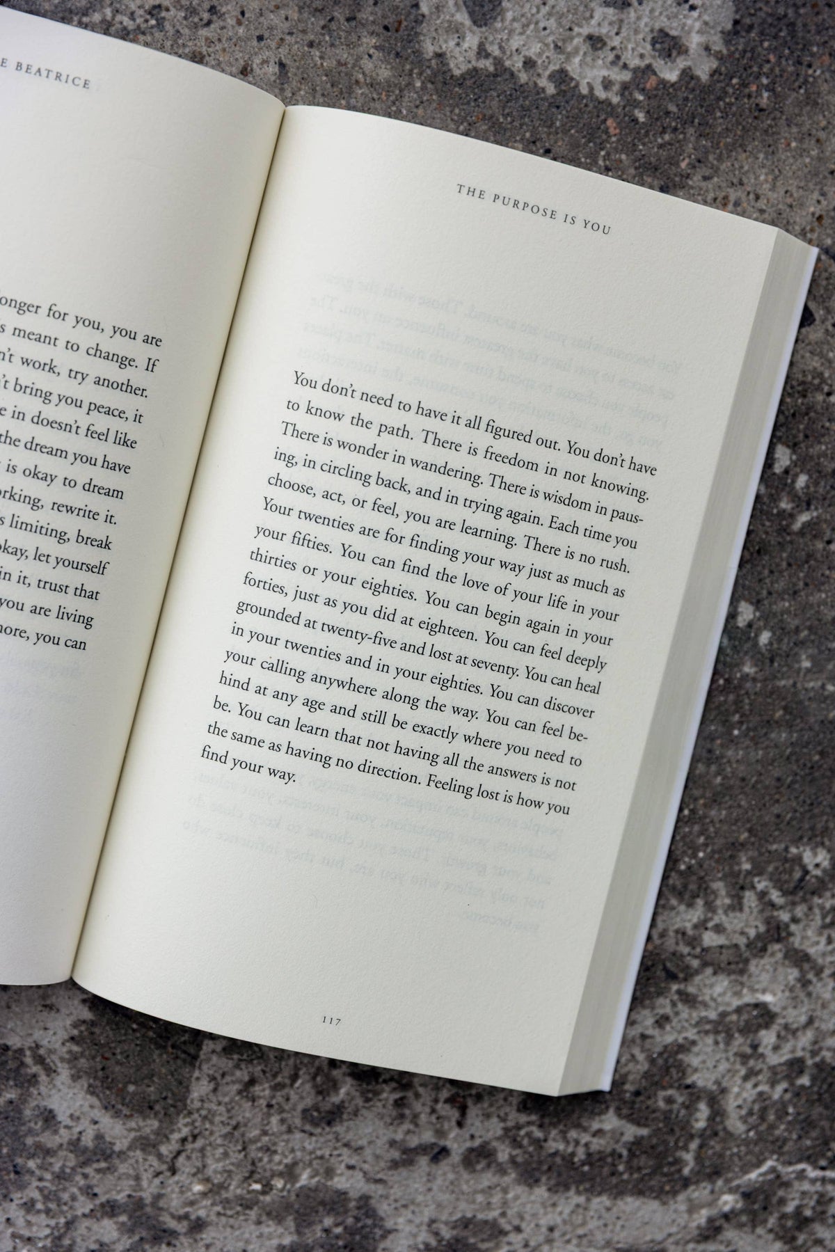 Open book on a textured surface with text visible