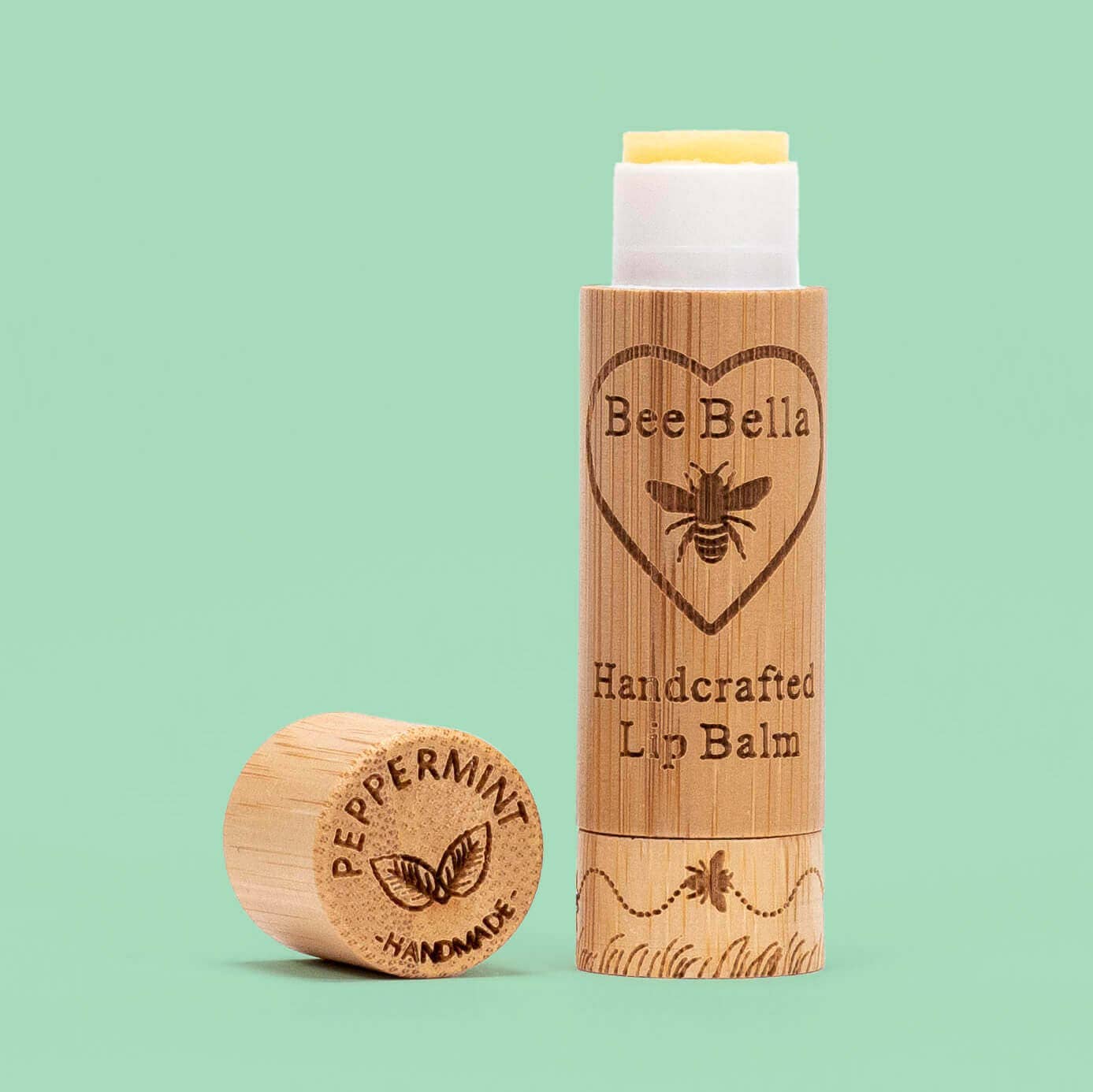 Bee Bella lip balm with wooden container on a light green background